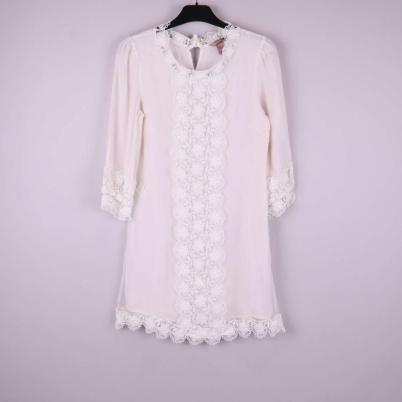 Vit klänning med spets i helfigur framifrån på galge