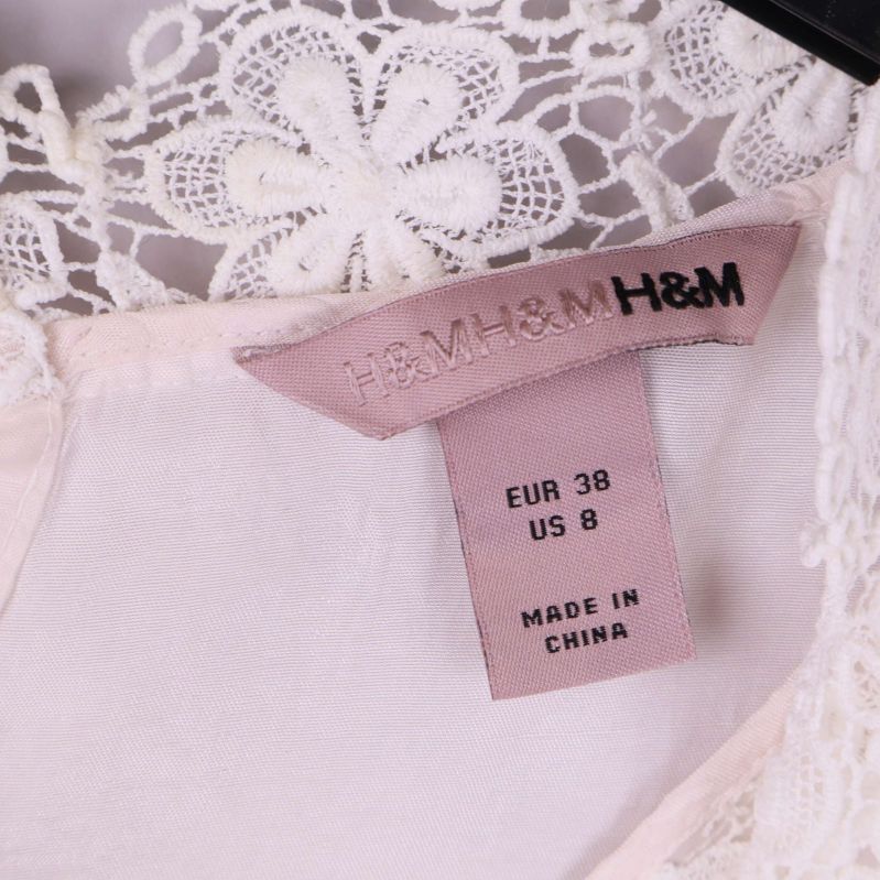 Närbild på H&M etikett och storlekslapp upptill i klänning