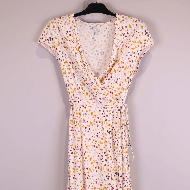 Närbild på omlottklänningens v-ringning och axel