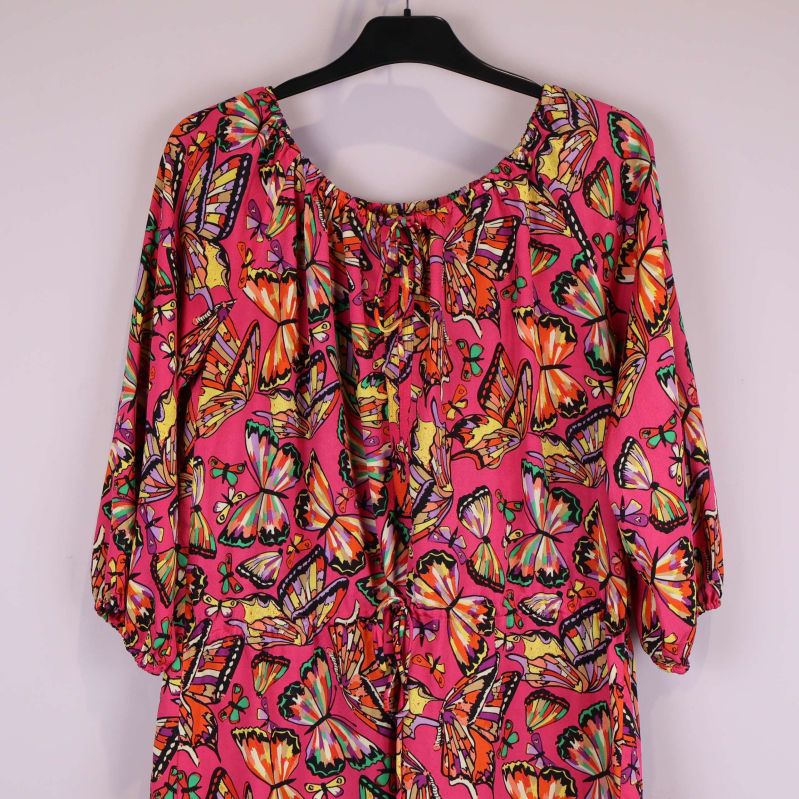 Närbild av halsringning och ärm med fjärilsmönster