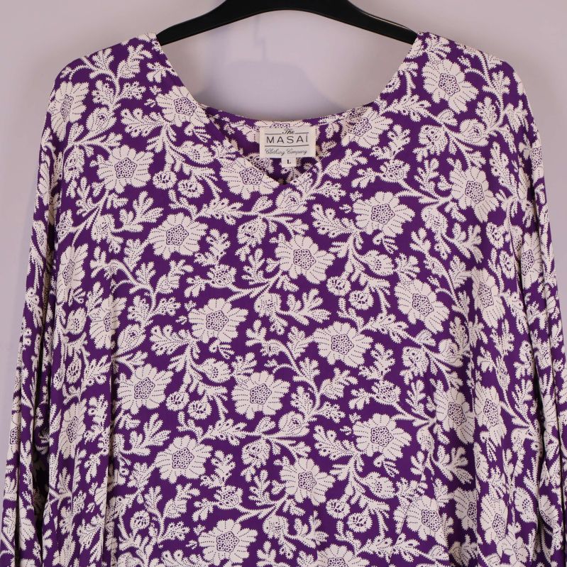 Närbild på blusens blommiga mönster och halsringning