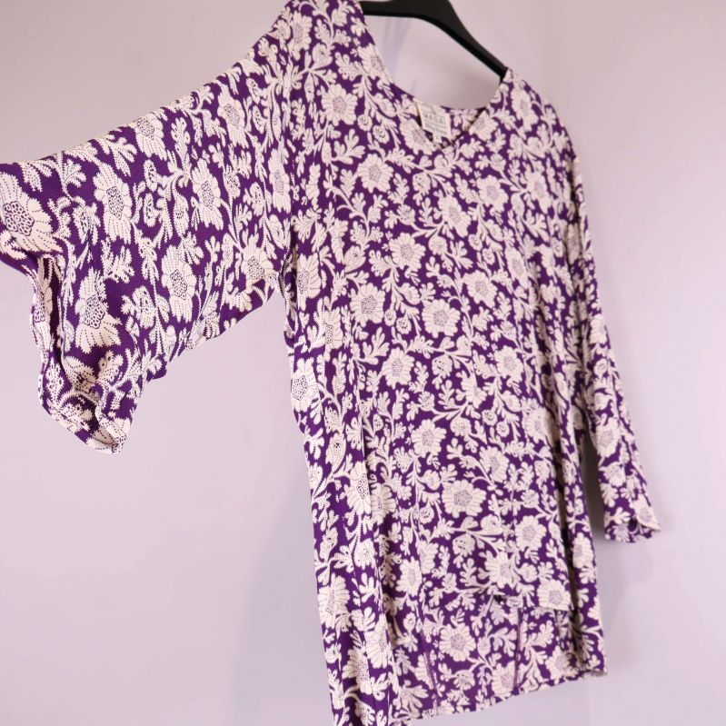 Blommig lila blus fotad från sidan för att visa ärm