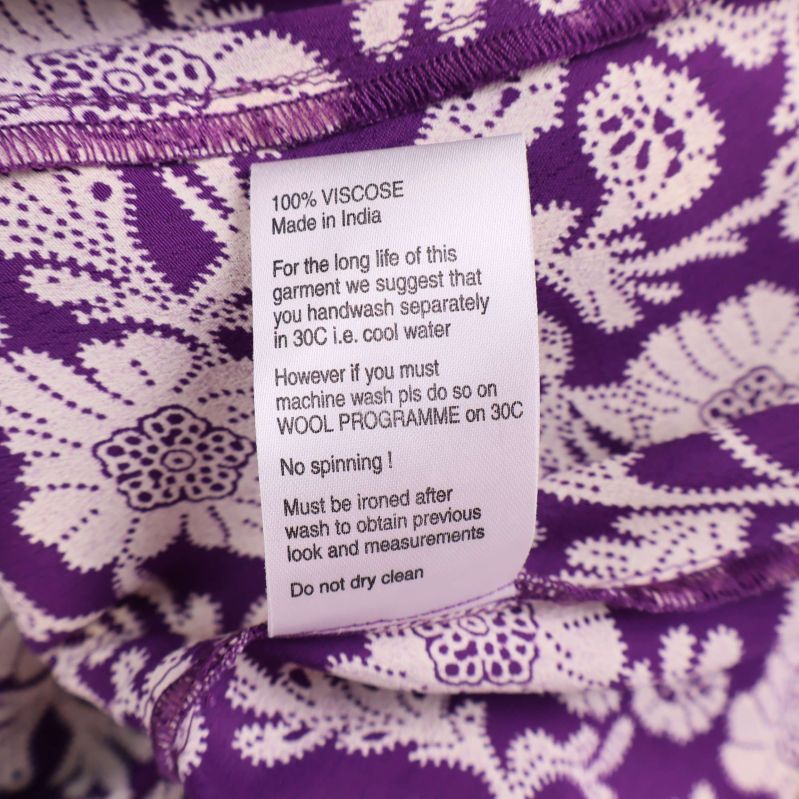 Materiallapp som visar 100% viskos och skötselråd