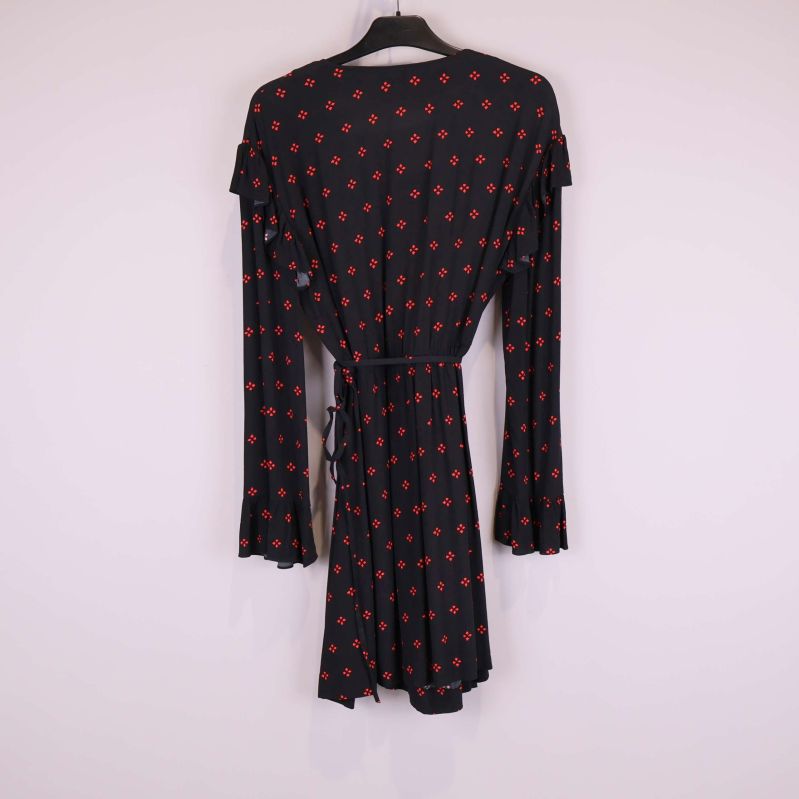 Baksidan av svart klänning med rött mönster och volangdetaljer