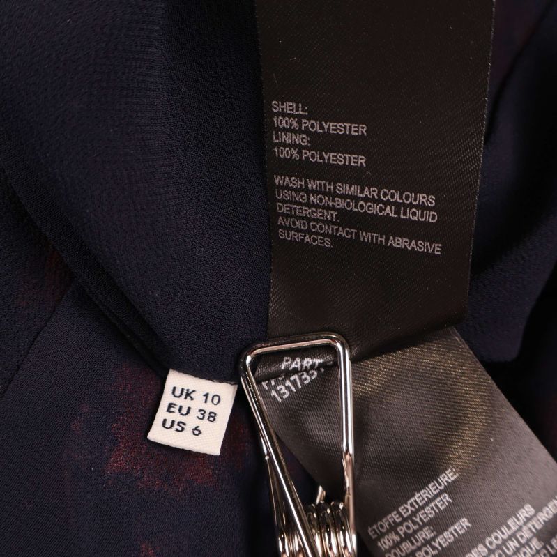 Materialetikett med information om polyester och EU-storlek 38