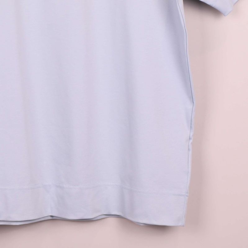 Närbild på nederkant av ljusst blå t-shirt