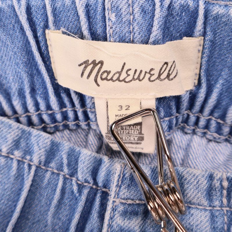 Närbild på etikett med märkning Madewell och storlek 32