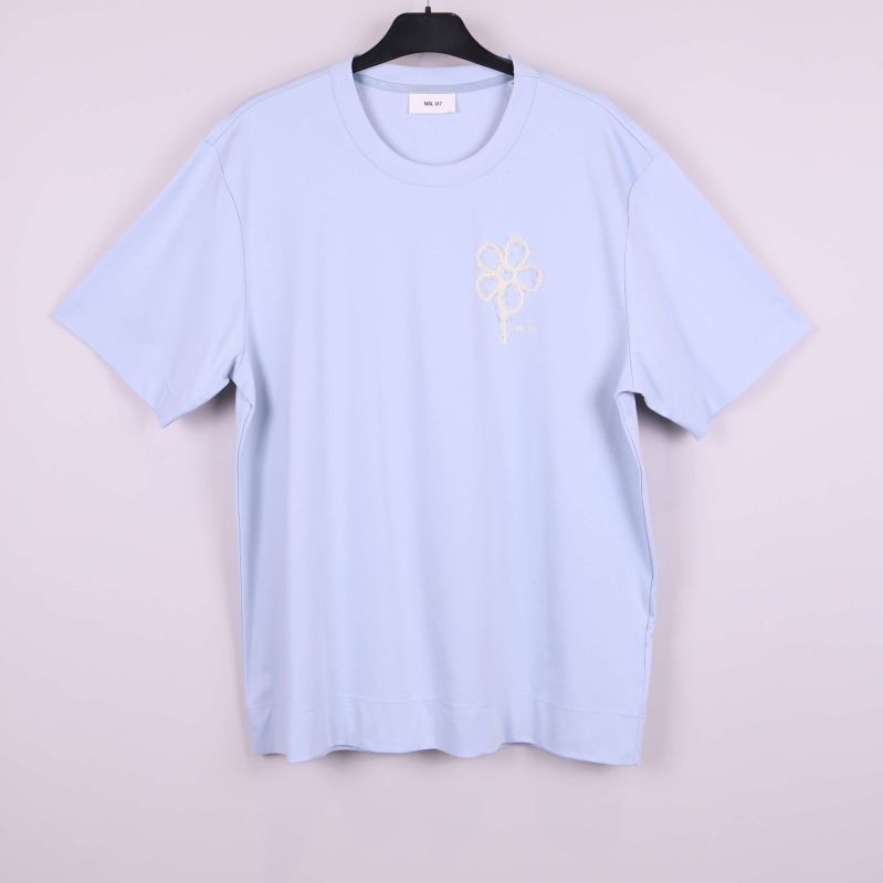 Ljusst blå t-shirt på galge 