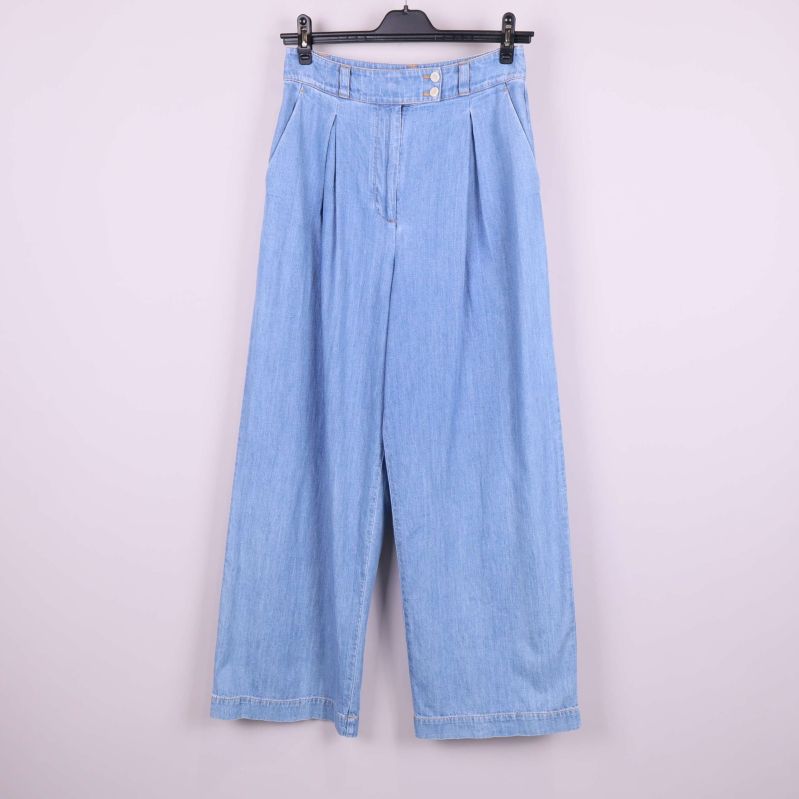 Framsida av vida ljusblå jeans på galge