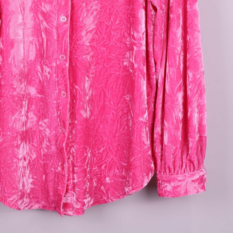 Närbild på skjortans nederdel och manschett i rosa velvet