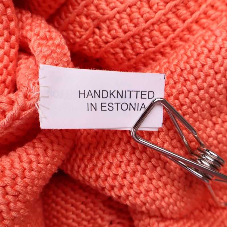 Etikett med texten handknitted in Estonia