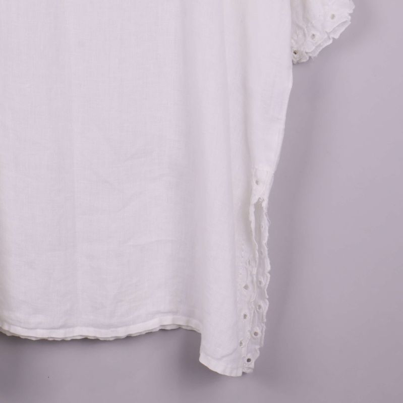 Närbild på nederkant av tunika med broderade sidor
