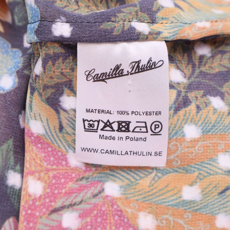 Materialetikett med information om 100% polyester