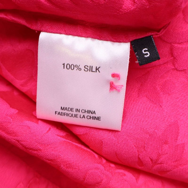 Materialetikett visar 100% silk på insidan av blusen