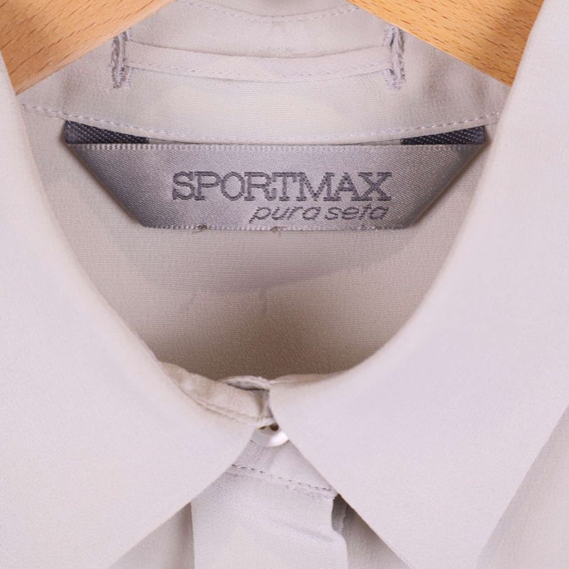 Närbild på Sportmax-märket i blusens krage