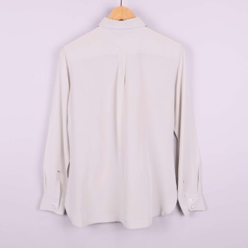 Baksida av vit långärmad blus med enkel design
