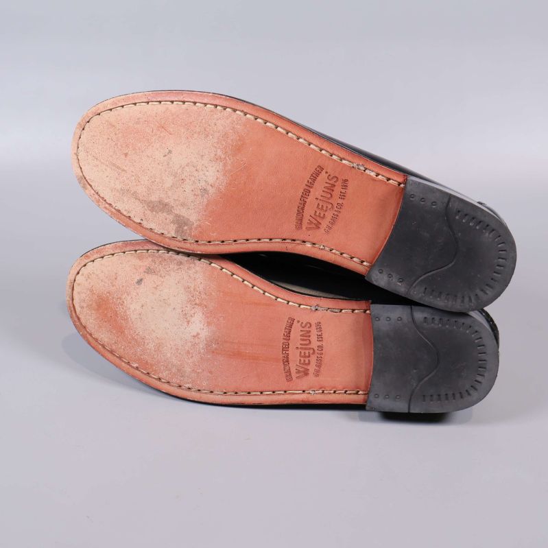 Undersida av loafers med text och slitage