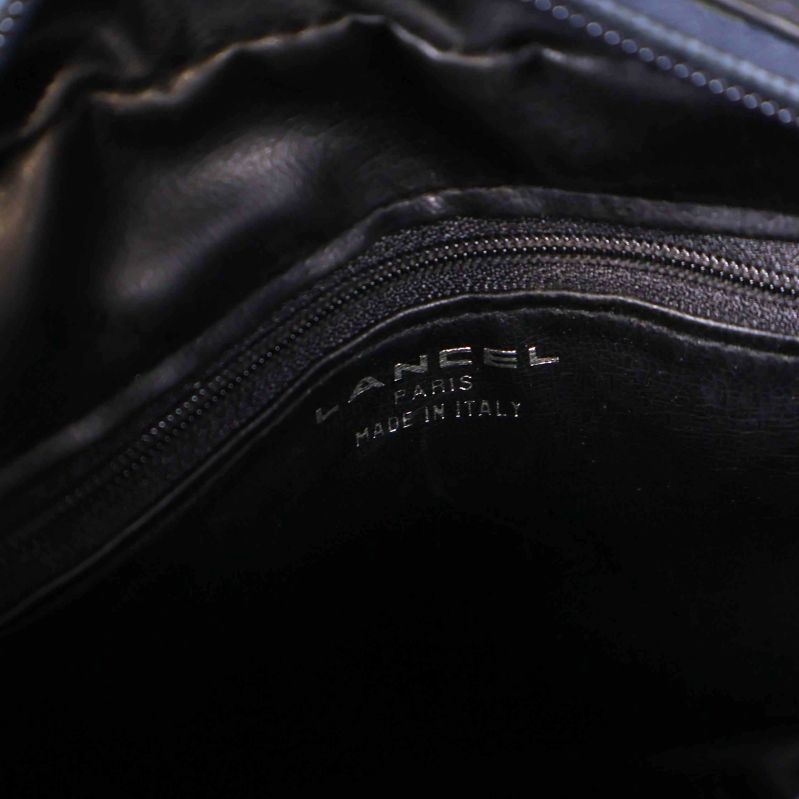 Närbild på väskans insida med präglad text Lancel Paris Made in Italy