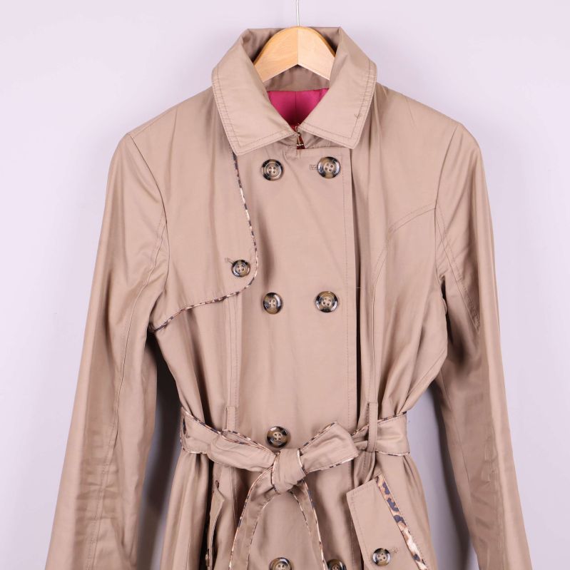 Övre del och krage på beige trenchcoat i närbild