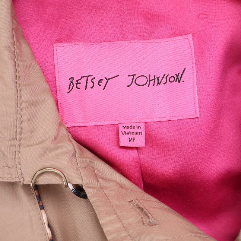 Närbild av Betsey Johnson-etikett mot rosa foder