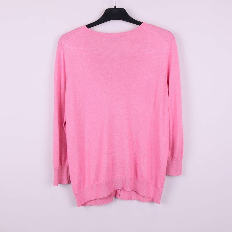 Baksidan av rosa cardigan visas på galge