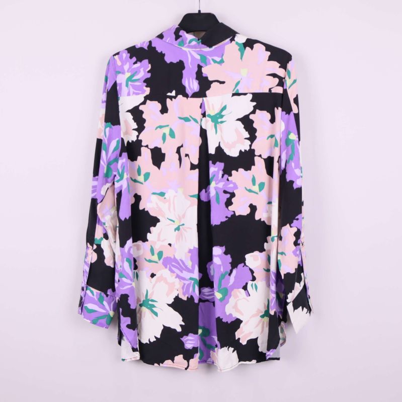 Baksidan av blommig långärmad blus på galge