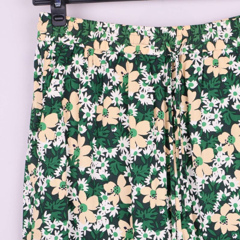 Detaljbild på shortsens blommönster och resårmidja