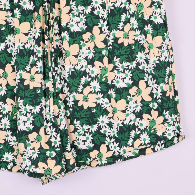 Närbild på shortsens nederkant och blommigt tyg