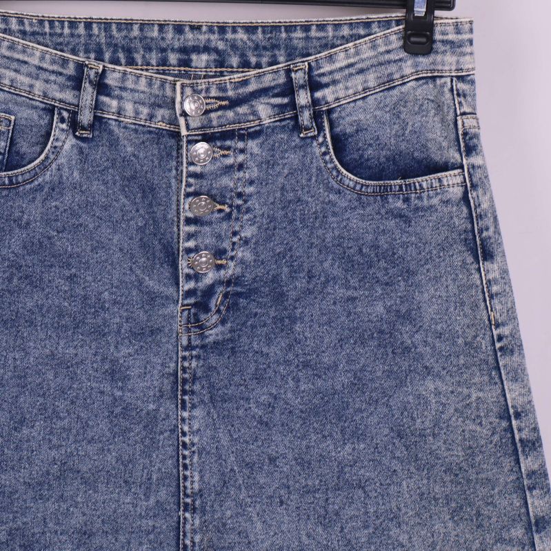 Närbild på denimkjolens knappgylf och framfickor