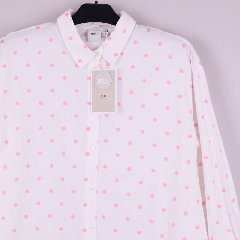 Överkropp och krage på vit skjorta med rosa prickar