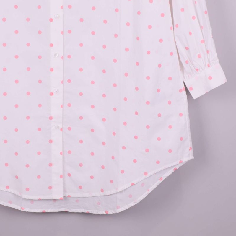 Närbild på skjortans nederkant med rosa prickar