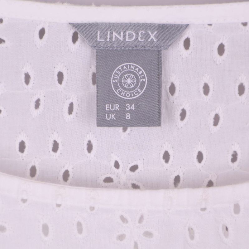 Närbild på ljust Lindex-märke och storleksetikett EUR 34