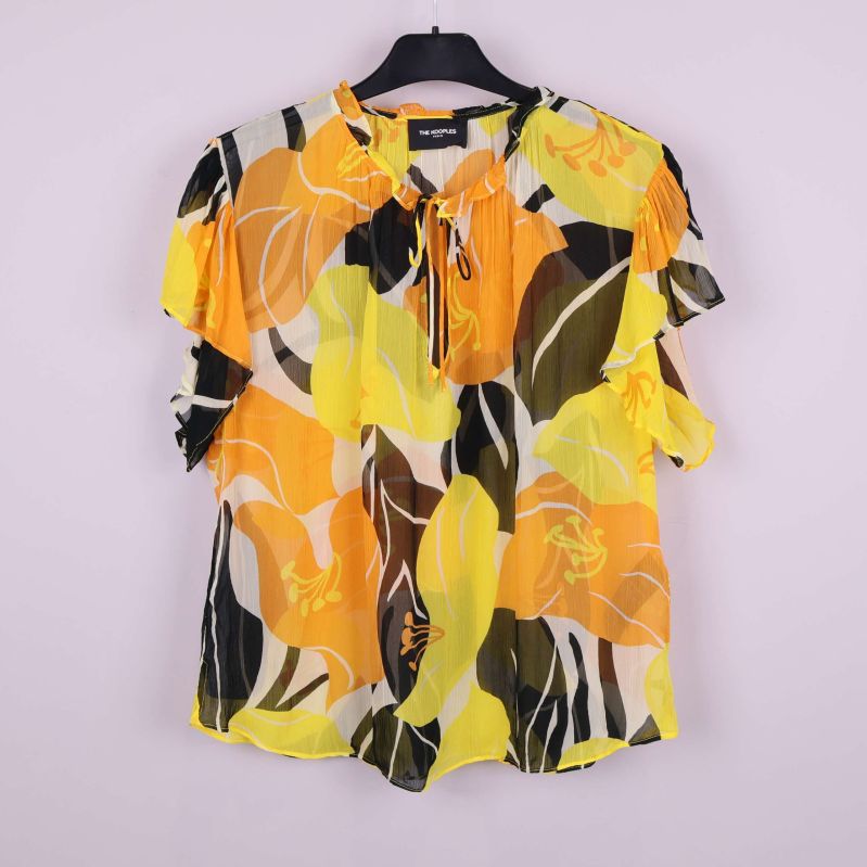 Blus med blommönster i gult och orange på galge framifrån