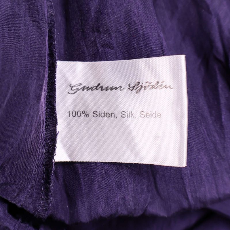 Materiallapp med texten 100% siden silk seide