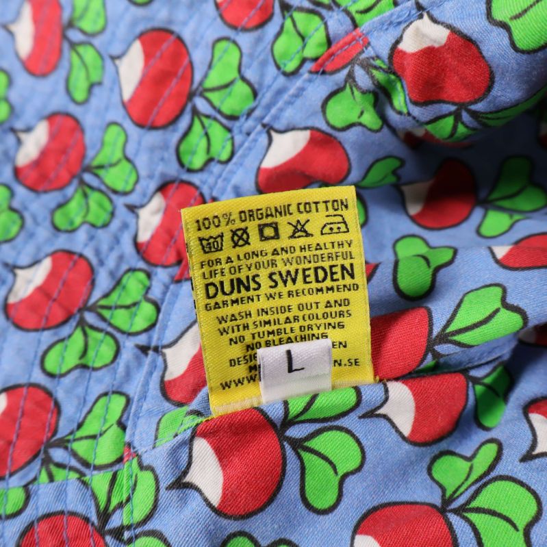 Materialetikett i hatt, anger 100% bomull från Duns Sweden, storlek L
