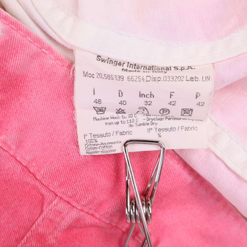 Material- och tvättetikett i jeansjackan visar sammansättning och skötselråd