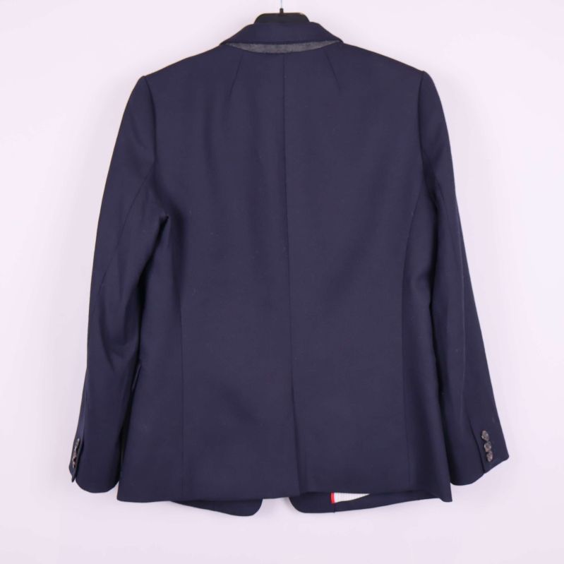 Baksidan av mörkblå blazer hängande på galge