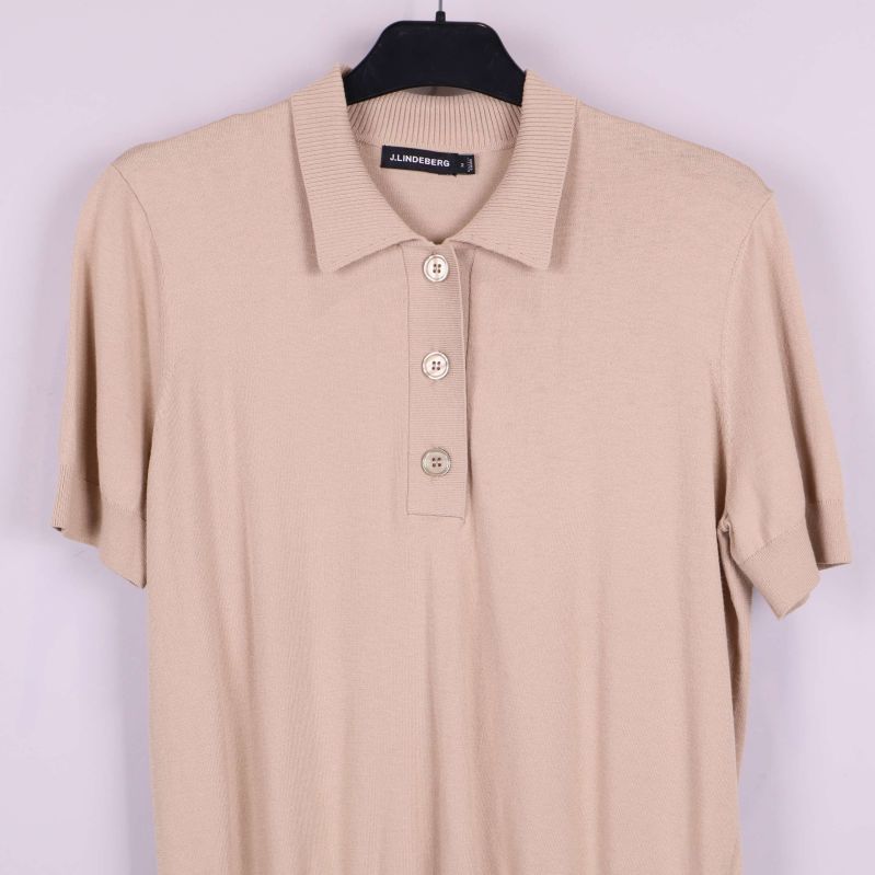 Närbild på överdelen av beige pikétröja