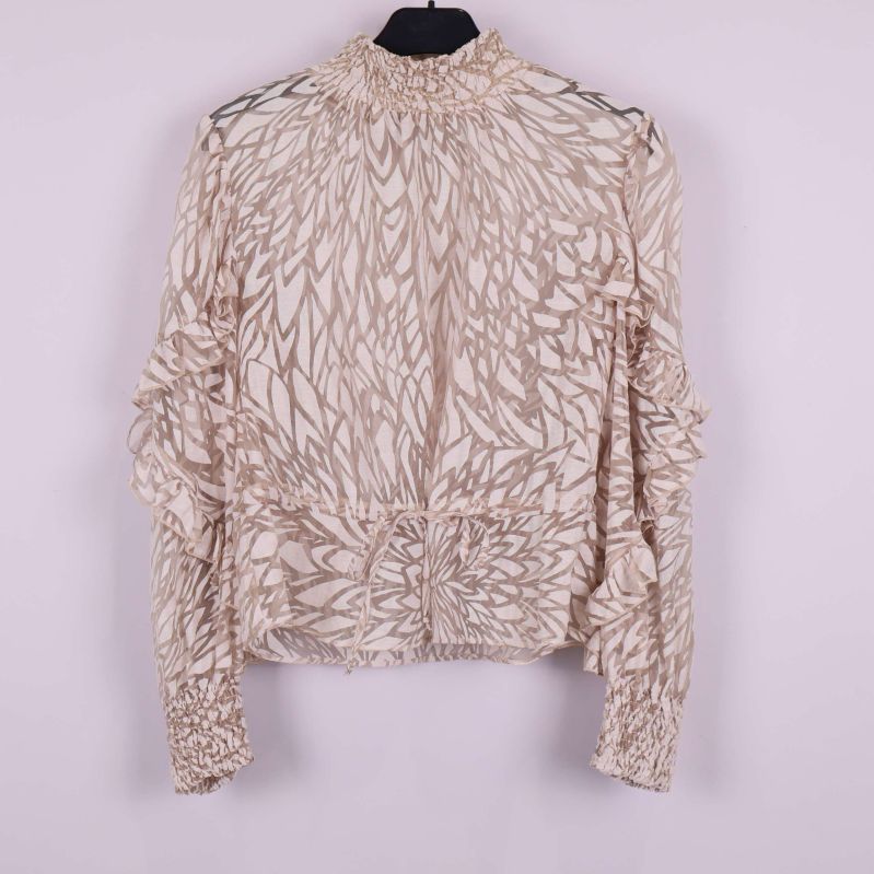Framsidan av mönstrad beige blus med volanger