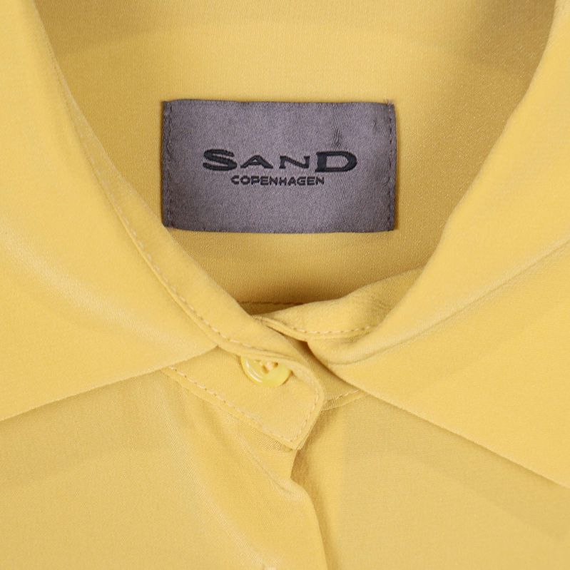 Närbild på Sand Copenhagen-märket inuti kragen