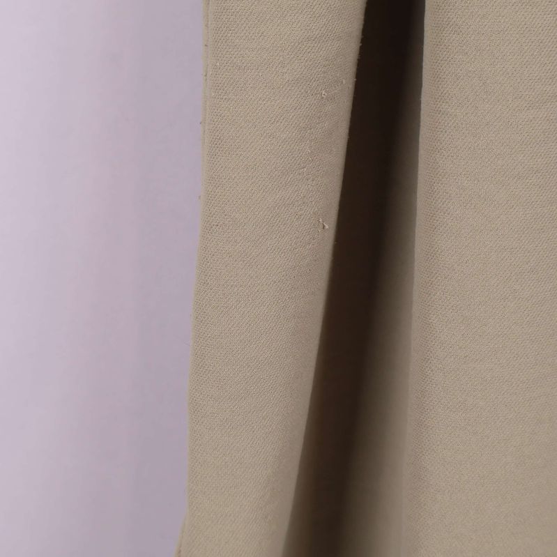 Detaljbild på tyget i beige skjortklänning i närbild