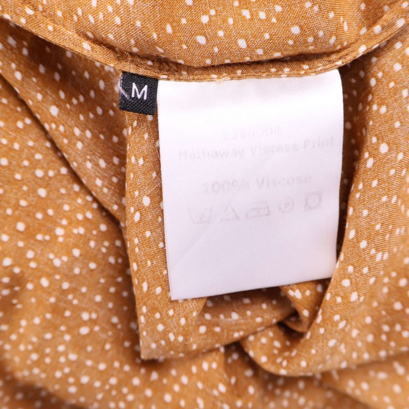 Materiallapp med information om 100% viskos och storlek M