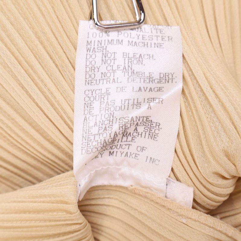 Etikett som visar skötselråd och 100% polyester