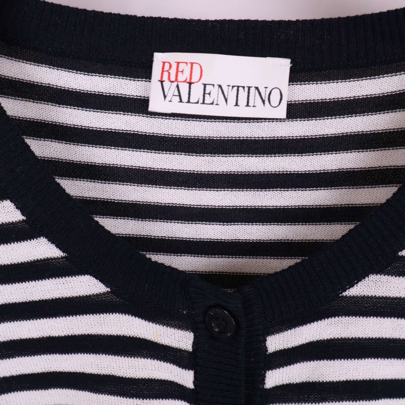 Närbild på Red Valentino-märket och mönstret vid halsen