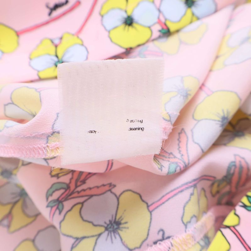Materialetikett med suddig text inuti blommig topp