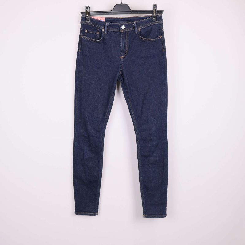 Jeans i mörkblå denim framifrån hängande på galge