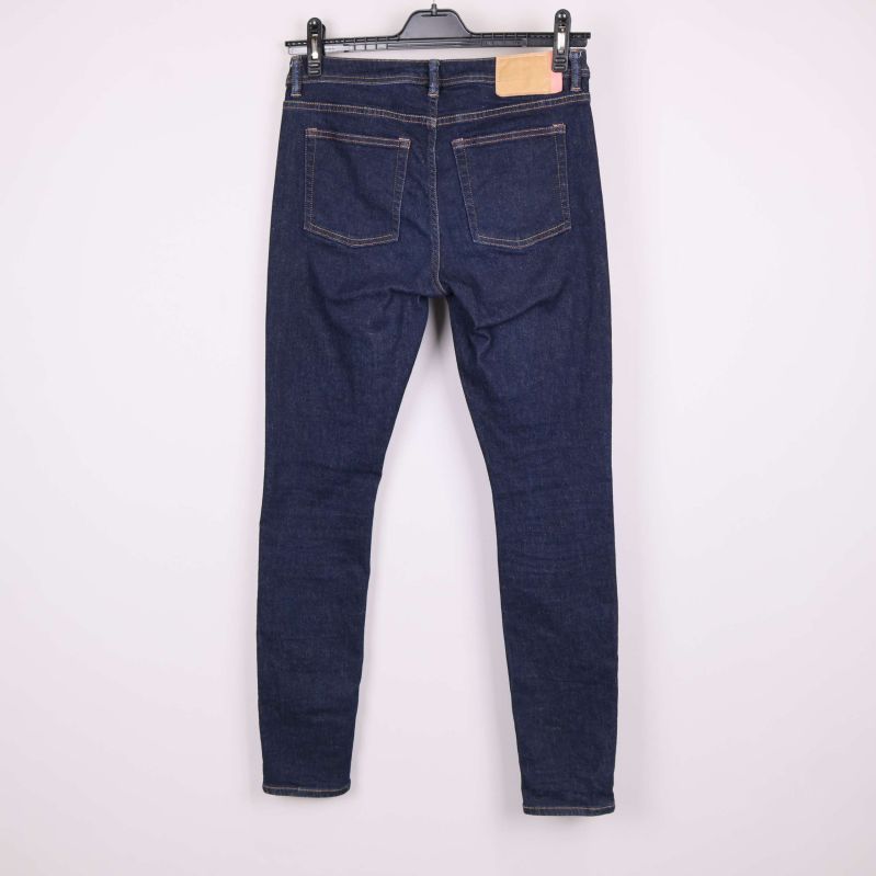 Baksida av jeans i mörk denim på galge