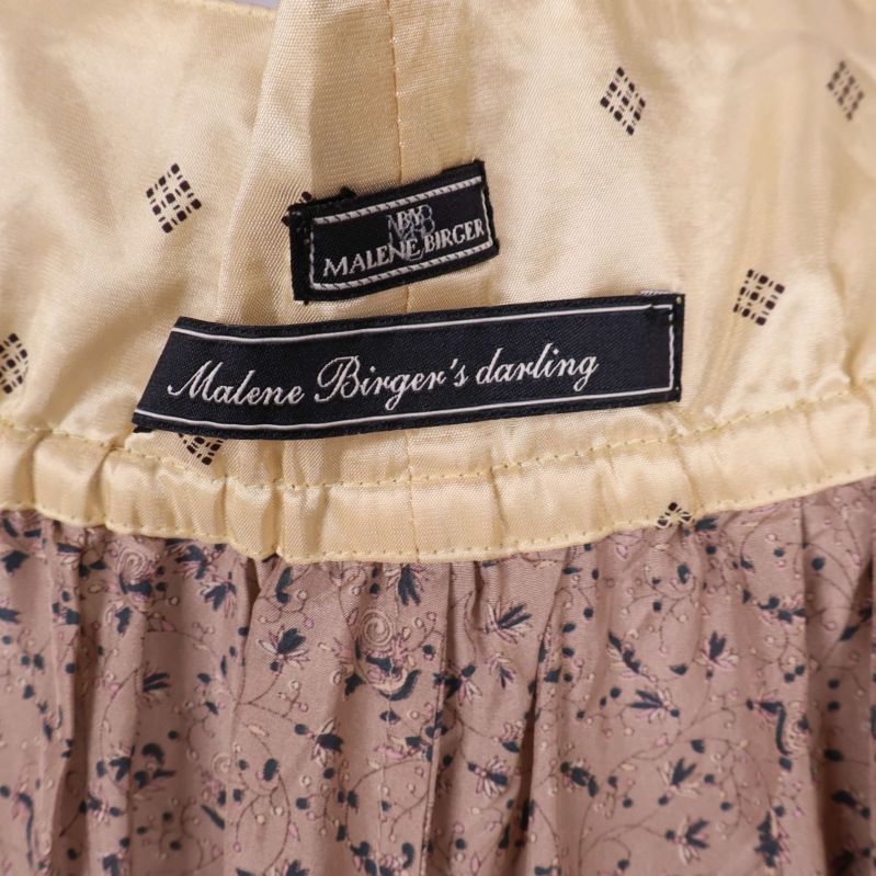 Närbild på etiketter med Malene Birger's darling-logga