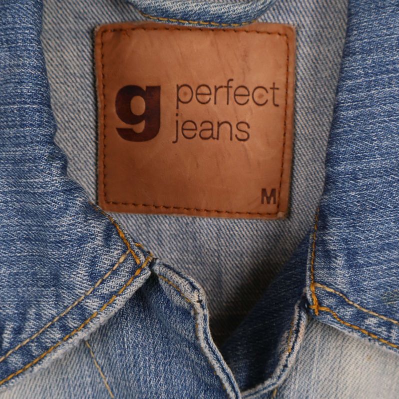 Närbild på brun etikett med texten g perfect jeans