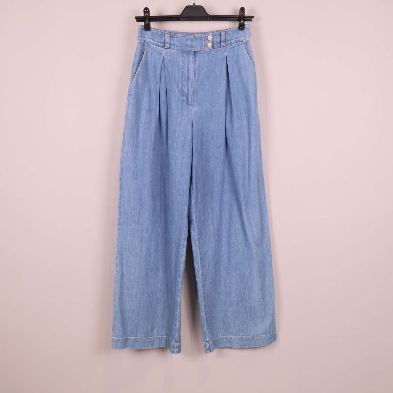 Framsida av vida ljusblå jeans på galge